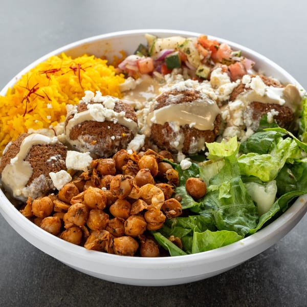 A Kabob Korner Mediterranean bowl with falafel, yellow rice, chickpeas, salad, and salsa.